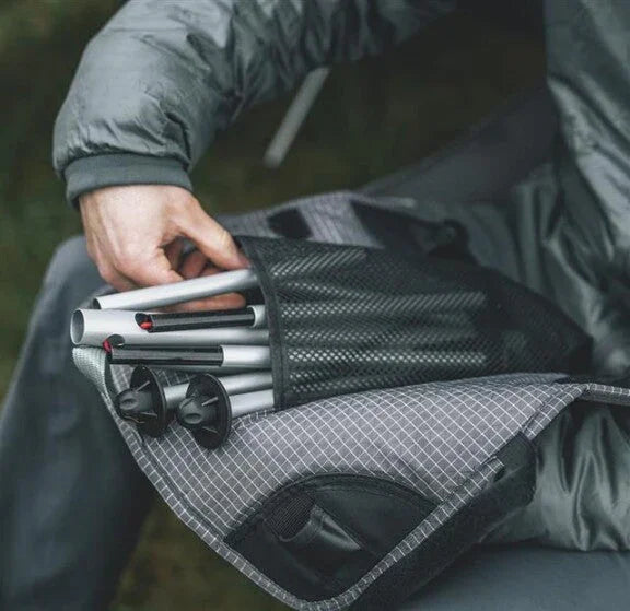 Compact camping tent poles stored in mesh carry bag, ideal for outdoor adventures and portable gear setup.