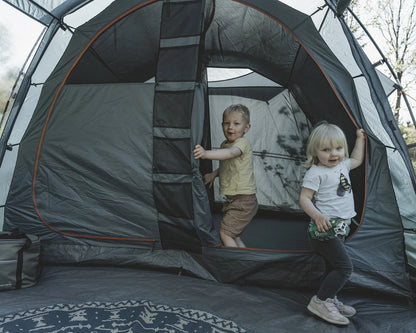 Kids playing in a spacious camping tent with orange trim, perfect for family outdoor adventures.