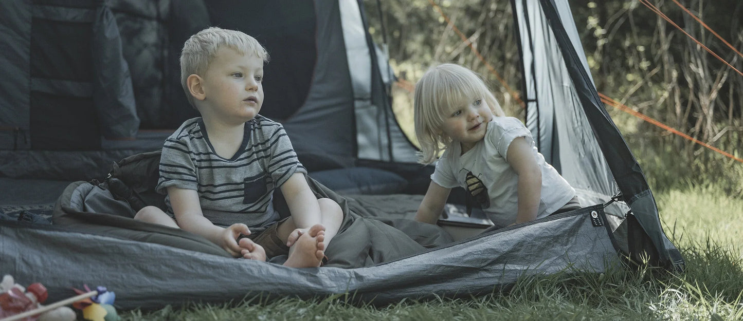 Kids enjoying camping adventure in tent with sleeping gear and outdoor fun