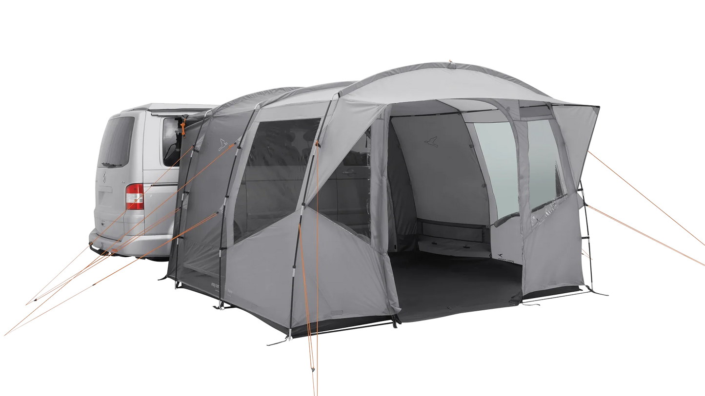 Gray motorhome awning with orange guy lines attached to van for outdoor camping setup