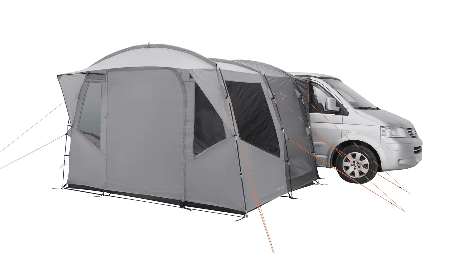 Gray motorhome awning attached to van, ideal for camping adventures and outdoor gear setups.
