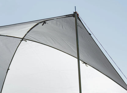 Gray camping awning with sturdy poles under clear sky