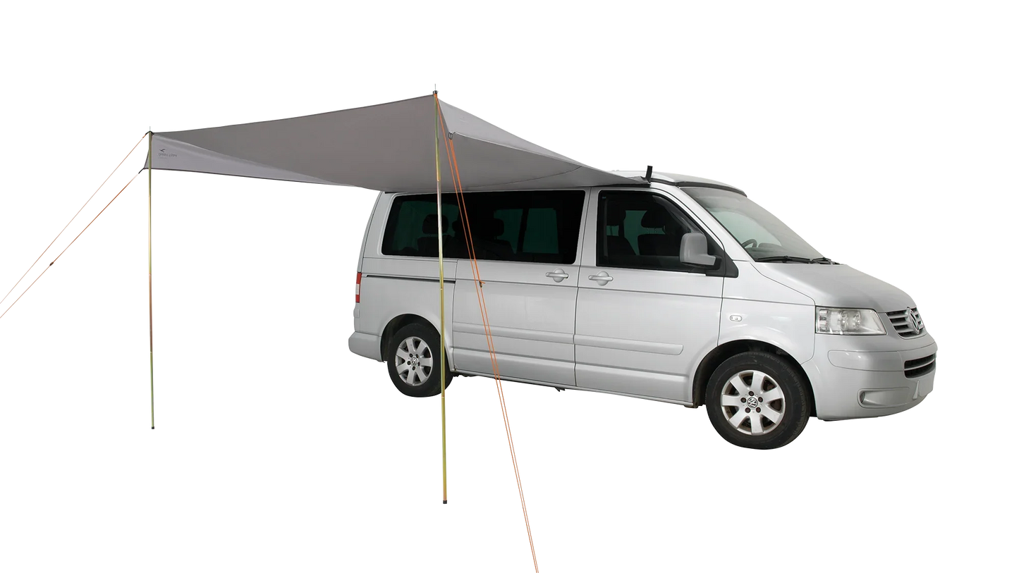 Motorhome awning attached to silver van for outdoor camping adventures