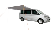 Motorhome awning attached to silver van for outdoor camping adventures