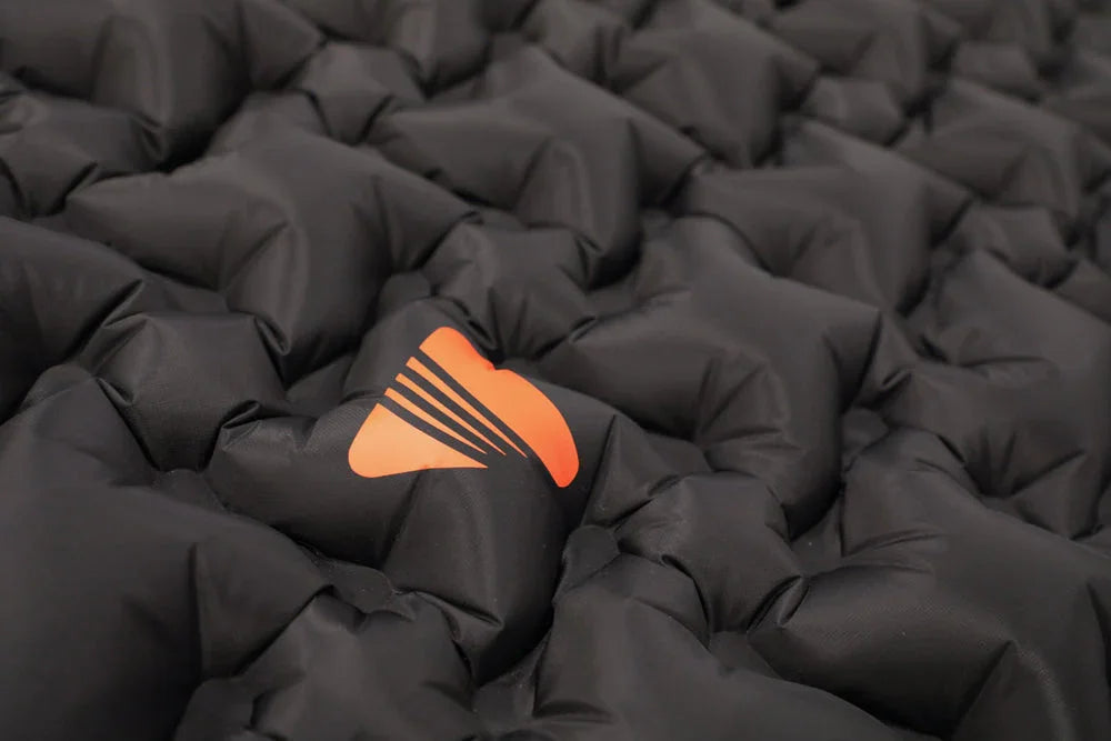 Black quilted camping sleeping pad with orange logo for outdoor adventures
