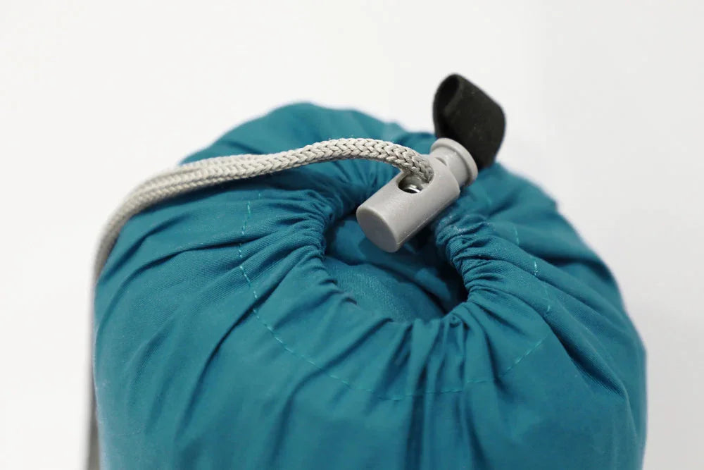 Teal camping gear stuff sack with drawstring closure, ideal for outdoor adventures and compact storage.