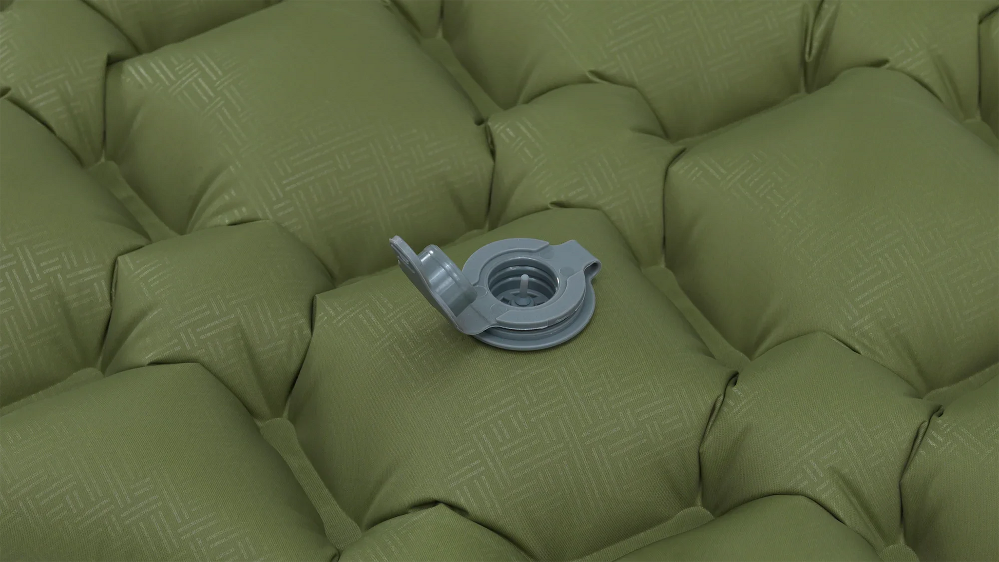 Green inflatable camping mattress with gray valve for outdoor adventures