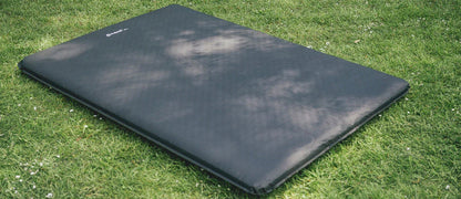 Black camping sleeping mat on grass, ideal for outdoor adventures and camping trips