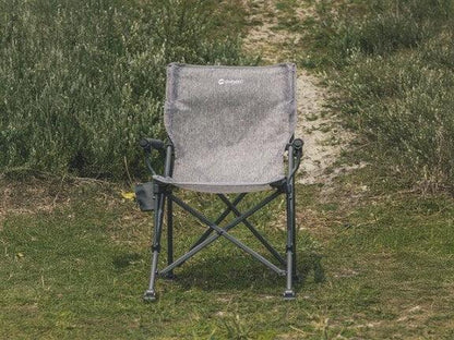 Gray folding camping chair on grass, ideal for outdoor adventures and picnics.
