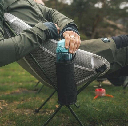 Camping chair with side pocket holding water bottle, ideal for outdoor adventures and caravanning trips.