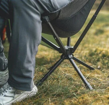 Portable camping chair with mesh back on grass, ideal for outdoor adventures and caravanning trips.