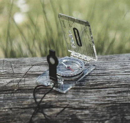 Clear compass on wooden surface for outdoor navigation and camping adventures