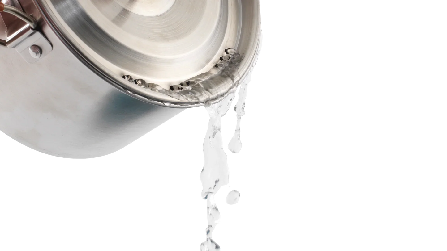 Stainless steel camping pot pouring water, ideal for outdoor cooking adventures