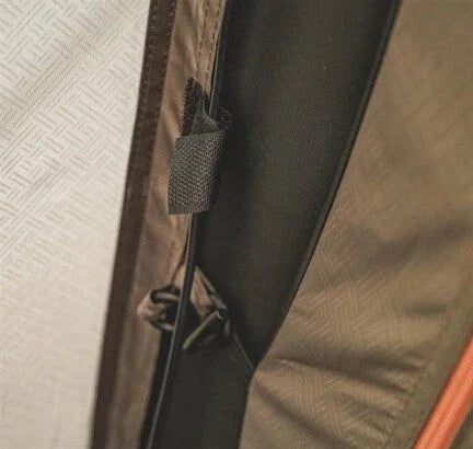 Close-up of durable tent fabric with secure strap and zipper detail for outdoor camping gear
