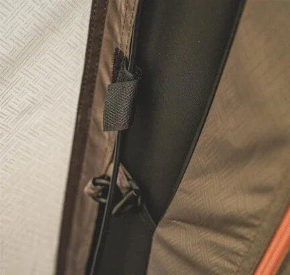 Close-up of durable tent fabric with secure strap and zipper detail for outdoor camping gear