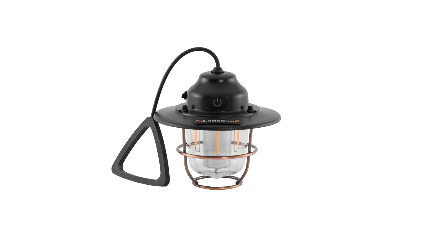 Portable camping lantern with copper cage and black handle for outdoor adventures