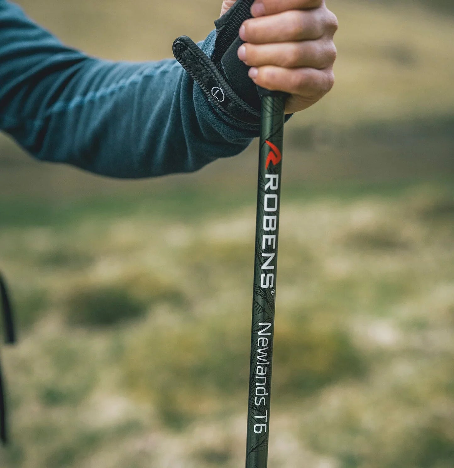 Robens Newlands T6 trekking pole held in hand, ideal for hiking and outdoor adventures.