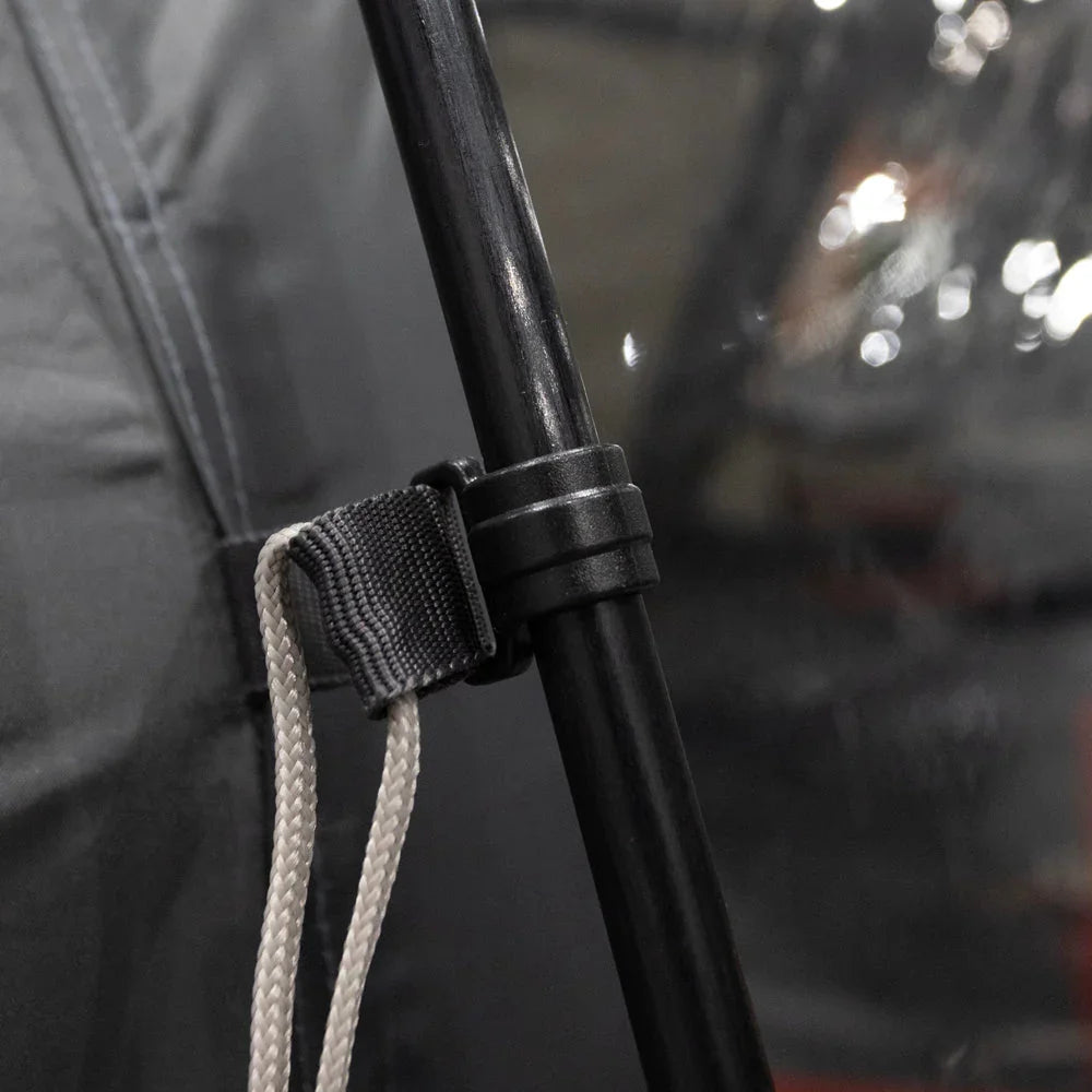 Black tent pole with adjustable strap and rope for camping gear setup