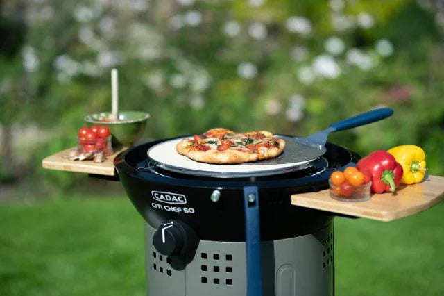 CADAC CM Chef 50 portable outdoor pizza oven with fresh toppings and garden backdrop