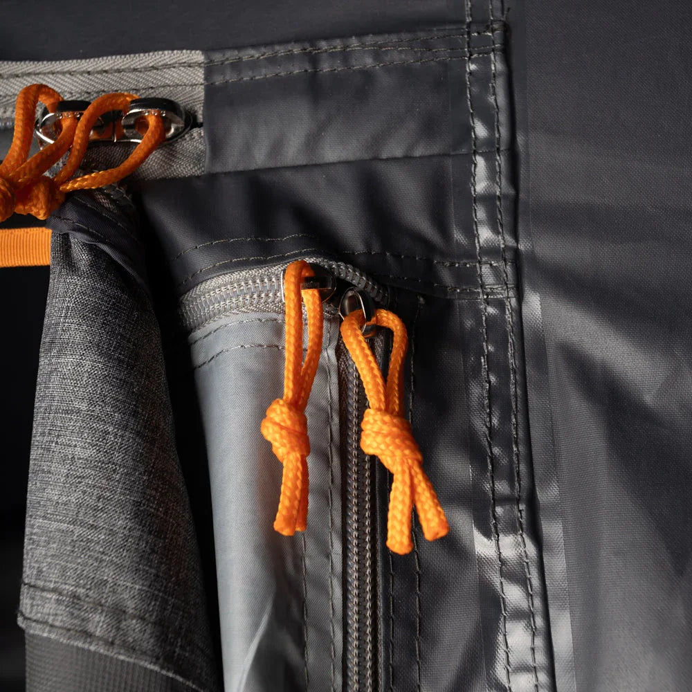 Close-up of durable camping tent zipper with orange rope pulls and reinforced stitching for outdoor gear