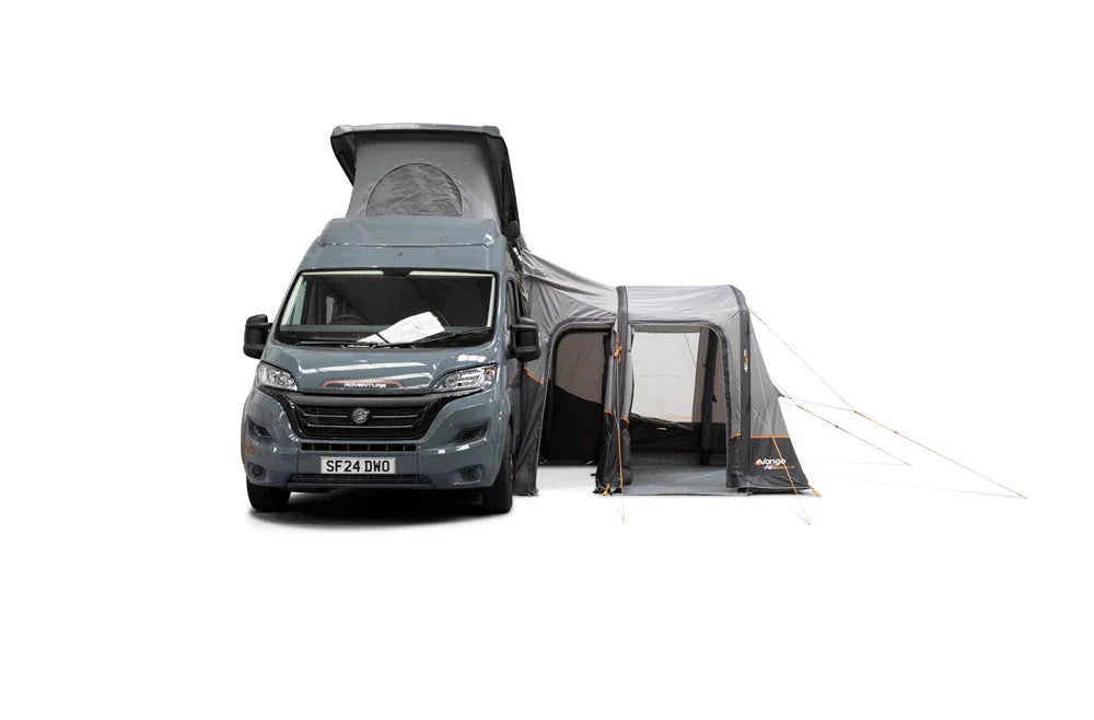 Grey motorhome with pop-up roof and attached awning for camping adventures