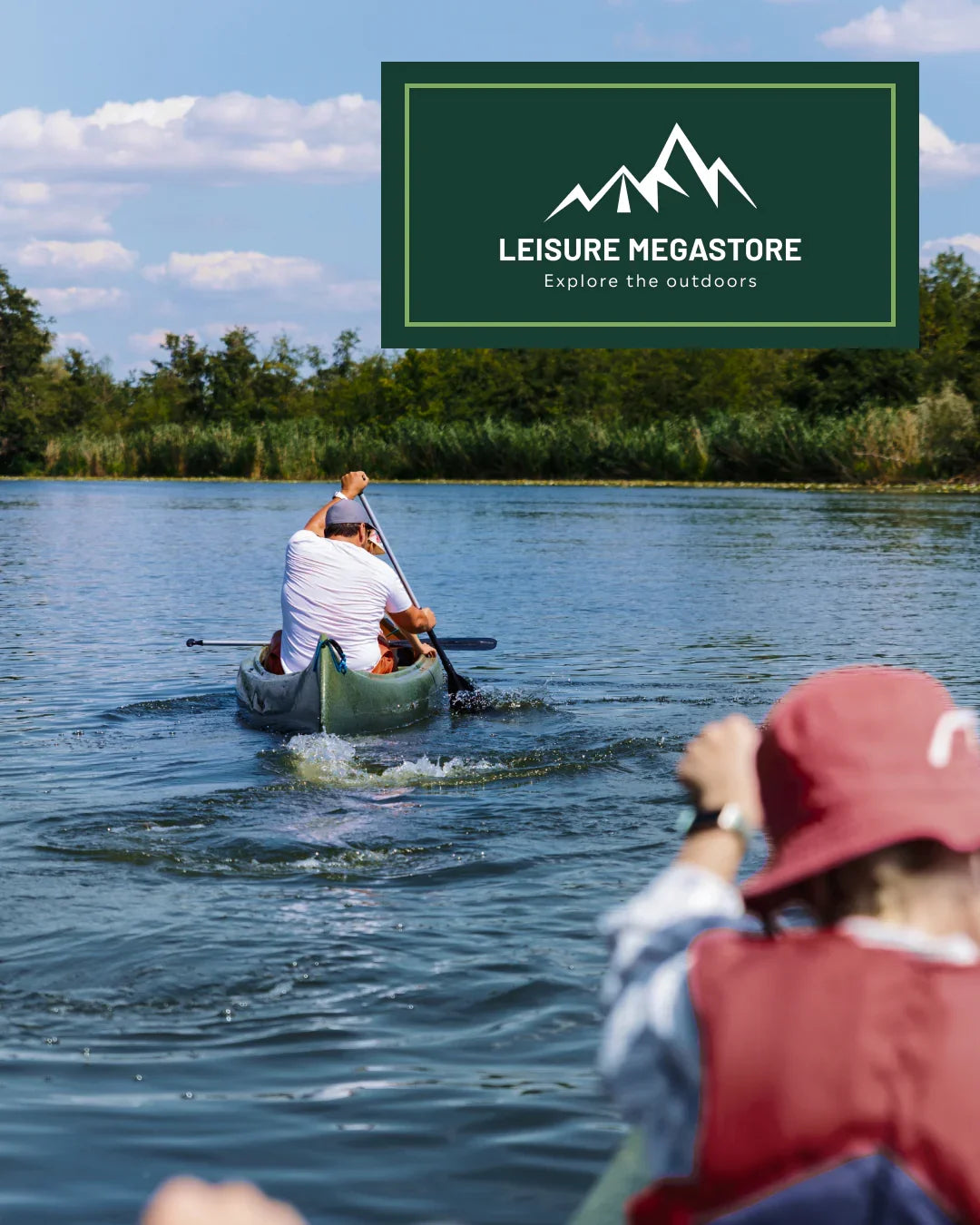 A person paddling a canoe on a lake with trees and blue sky in the background, plus a large dark green 'LEISURE MEGASTORE Explore the outdoors' logo overlay in the top right.