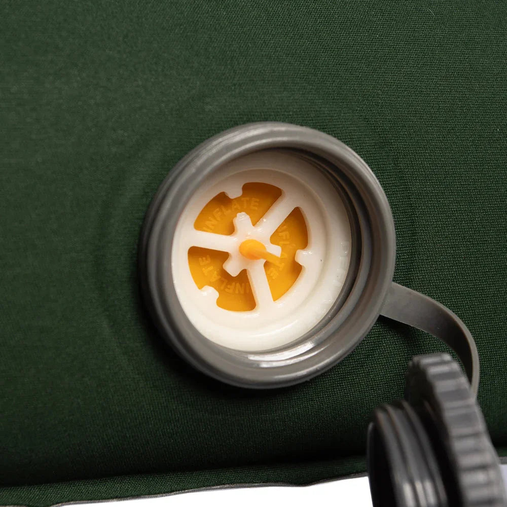 Inflate valve on green camping air mattress for outdoor adventures