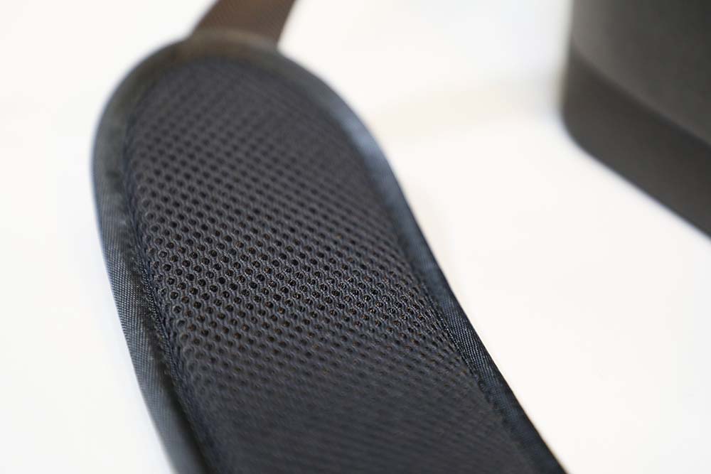 Close-up of a black mesh office chair seat on a white background