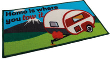 Doormat with a camper design and text 'Home is where you tow it' on a blue background