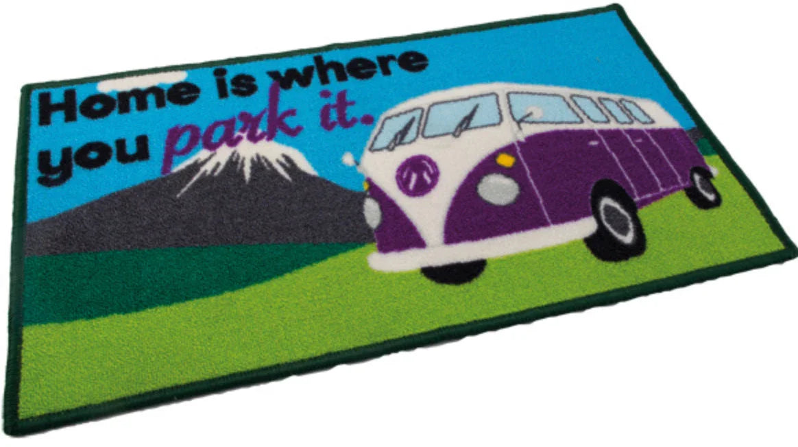 Doormat with a purple van and text 'Home is where you park it.' on a blue and green background