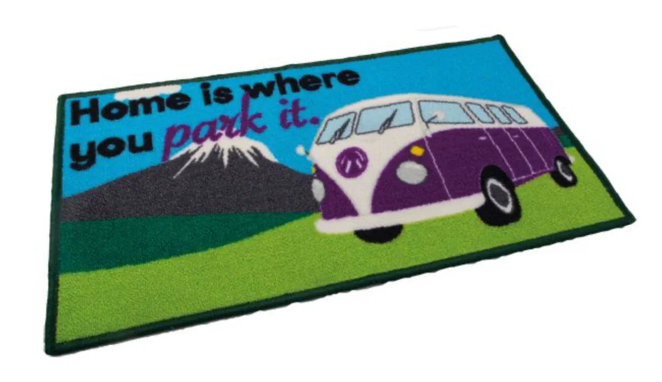 Doormat with a purple van and text 'Home is where you park it.' on a white background