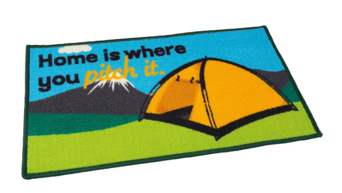 Doormat with a tent design and text 'Home is where you pitch it.' on a blue and green background.