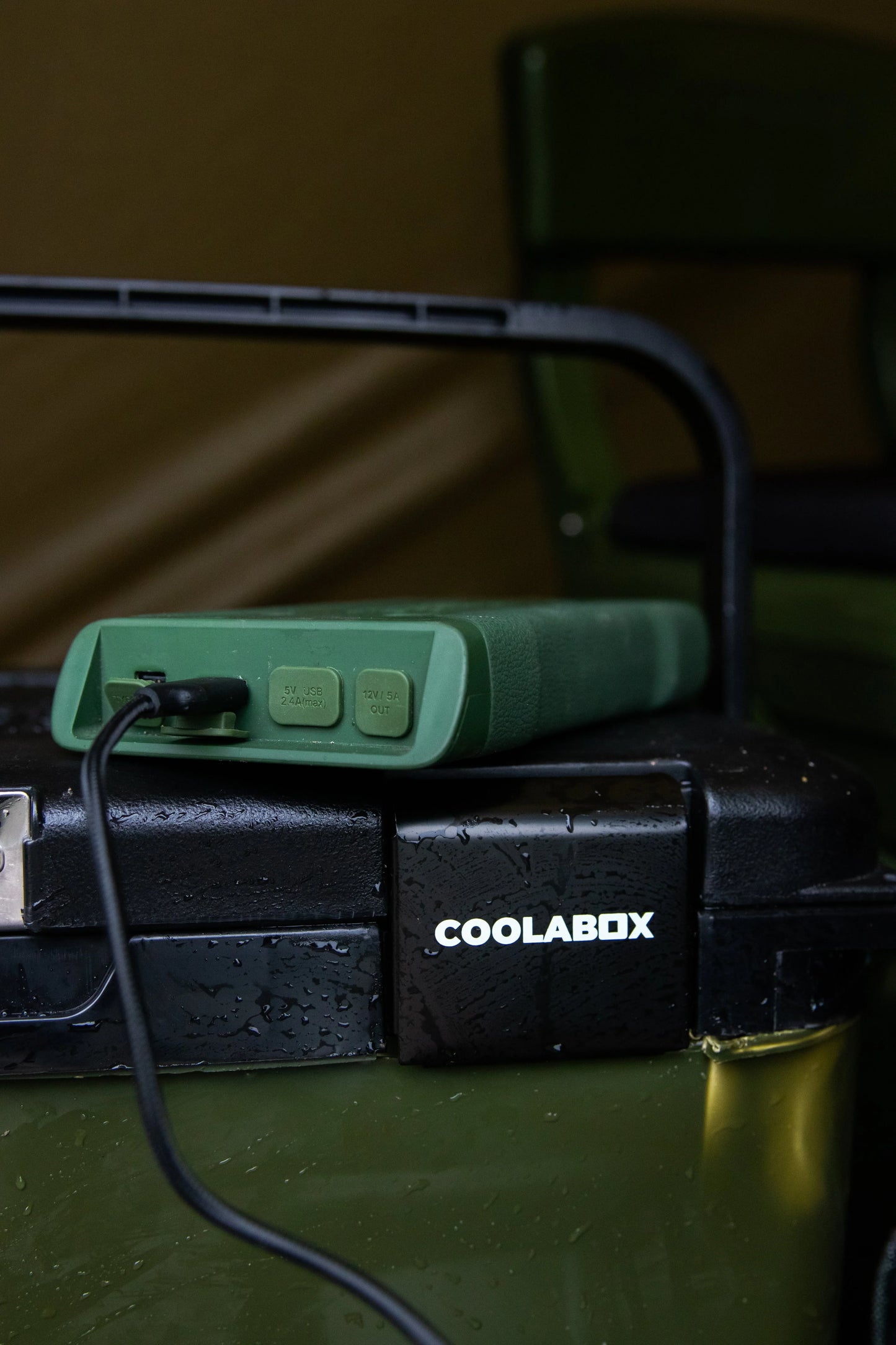 Green portable power bank charging COOLABOX cooler for camping adventures